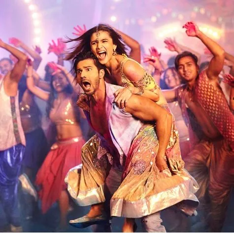 Varun Dhawan performs a vibrant dance scene in traditional attire, showcasing his comedic charm and energetic presence typical of his films like 'Badrinath Ki Dulhania.'